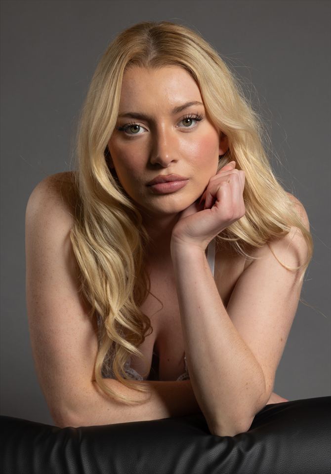 Blonde Frau, das Kinn auf die Hände gestützt